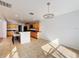 Open concept kitchen with wooden cabinets, bar seating, tile floors, and stylish light fixture at 1176 Liberty Hall Dr, Kissimmee, FL 34746