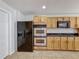 Kitchen with stainless appliances, double oven, wood cabinets, and tile floor at 1176 Liberty Hall Dr, Kissimmee, FL 34746