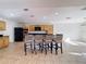 Open kitchen with bar seating, wooden cabinets, and modern appliances at 1176 Liberty Hall Dr, Kissimmee, FL 34746