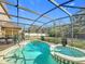 Screened-in pool with an attached spa and an expansive backyard area in a well-manicured, lush setting at 1176 Liberty Hall Dr, Kissimmee, FL 34746
