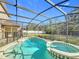 Screened-in pool with an attached spa and an expansive backyard area in a well-manicured, lush setting at 1176 Liberty Hall Dr, Kissimmee, FL 34746