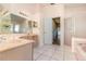 Bathroom with double vanity, large mirror, tile floor, glass shower, and tub at 12213 Bohannon Blvd, Orlando, FL 32824
