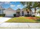 Charming single-story home featuring a well-manicured lawn, palm trees, and a two-car garage at 12213 Bohannon Blvd, Orlando, FL 32824