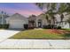 Charming single-story home featuring a well-manicured lawn, palm trees, and a two-car garage at 12213 Bohannon Blvd, Orlando, FL 32824
