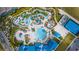 Aerial view of resort-style pool with winding lazy river, splash pad, and colorful umbrellas at 136 Jetty Way, Davenport, FL 33897