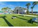 An outdoor amenity area features cornhole, seating, palm trees, and a pool view on a sunny day at 136 Jetty Way, Davenport, FL 33897