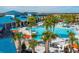 Stunning community pool with ample seating, umbrellas, and lush palm trees at 136 Jetty Way, Davenport, FL 33897