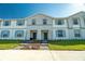 Charming townhome with neat front lawn and blue shutters against a clear blue sky at 136 Jetty Way, Davenport, FL 33897