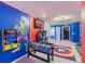 Vibrant game room featuring arcade games, a foosball table, and colorful superhero murals at 136 Jetty Way, Davenport, FL 33897