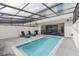Private backyard pool with sun loungers and a covered enclosure, perfect for outdoor enjoyment at 136 Jetty Way, Davenport, FL 33897
