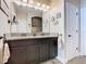 Bathroom featuring dark cabinets, double sinks, granite countertop, updated tiling and walk in shower at 1410 Resolute St, Celebration, FL 34747