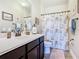 Well-lit bathroom with a clean white sink, vanity, and a shower with a decorative curtain at 1410 Resolute St, Celebration, FL 34747