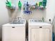 Bright laundry room with a white, front-load washer and dryer, and ample storage at 1410 Resolute St, Celebration, FL 34747