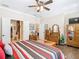 Comfortable main bedroom with hardwood floors, striped bedding, ceiling fan and en-suite bathroom access at 1410 Resolute St, Celebration, FL 34747
