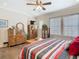 Comfortable main bedroom with hardwood floors, striped bedding, ceiling fan, and sitting area at 1410 Resolute St, Celebration, FL 34747