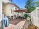 Charming backyard patio with brick flooring, outdoor seating, umbrella, and decorative plants at 1410 Resolute St, Celebration, FL 34747