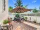 Private patio with brick pavers, umbrella-covered table and chairs, plus colorful landscaping at 1410 Resolute St, Celebration, FL 34747