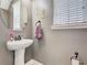 Stylish powder room with pedestal sink and decorative accents, and soft gray walls at 1410 Resolute St, Celebration, FL 34747