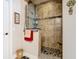 Beautiful bathroom walk-in shower with neutral tile and stone pebble floor at 1410 Resolute St, Celebration, FL 34747
