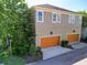 Two-story home featuring a two-car garage with vibrant orange doors and neat landscaping at 14188 Walcott Ave, Orlando, FL 32827
