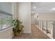 Second floor hallway with neutral carpet, plant and stainless steel railing at 14188 Walcott Ave, Orlando, FL 32827