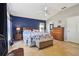 Bright main bedroom with a blue accent wall, tile floors, and an ensuite bathroom at 149 Southern Breeze Dr, Minneola, FL 34715