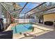 Sparkling pool inside screened enclosure with decorative string lights overhead at 149 Southern Breeze Dr, Minneola, FL 34715