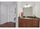 Well-lit bathroom with wooden vanity, granite countertop, decorative flowers, and modern fixtures at 150 E Robinson St # 1219, Orlando, FL 32801
