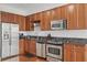 Well-equipped kitchen with stainless steel appliances, wooden cabinets, and dark countertops at 150 E Robinson St # 1219, Orlando, FL 32801