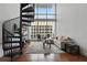 Bright living area with large windows, spiral staircase, comfortable seating, and stylish decor on hardwood floors at 150 E Robinson St # 1219, Orlando, FL 32801