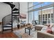 Inviting living room with spiral staircase, hardwood floors, stylish rug, comfortable sofa, and large windows at 150 E Robinson St # 1219, Orlando, FL 32801