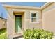 Close-up of the front entrance featuring a stylish green door and manicured shrubs at 156 Eagleview Loop, Davenport, FL 33837