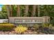 The Lake Jesup Woods community sign framed by various lush greenery and palm trees at 1563 Song Sparrow Ct, Sanford, FL 32773