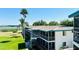 Two-story condo building featuring outdoor walkways, screened-in patios, and lush landscaping with lake views at 1600 W Lake Parker Dr # C24, Lakeland, FL 33805