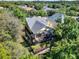 Aerial shot showcasing the house with screened patio and fenced backyard surrounded by lush greenery at 1626 Victoria Gardens Drive, Deland, FL 32724
