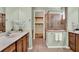 Elegant bathroom with double vanity, wooden cabinets, tiled floors, and glass shower with walk-in closet view at 1626 Victoria Gardens Drive, Deland, FL 32724