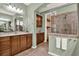 Stylish bathroom with double vanity, wood cabinets, and tiled shower with glass door and linen storage at 1626 Victoria Gardens Drive, Deland, FL 32724