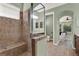 Bathroom showcasing a tiled shower, dual vanity, and arched doorway to the primary suite at 1626 Victoria Gardens Drive, Deland, FL 32724