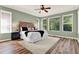 Bedroom with light-green walls, white bedding, a ceiling fan and large windows for lots of natural light at 1626 Victoria Gardens Drive, Deland, FL 32724
