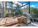 Expansive screened patio featuring a hot tub, grill, and brick accents, perfect for outdoor living at 1626 Victoria Gardens Drive, Deland, FL 32724