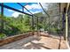 Spacious screened patio with brick flooring and an outdoor grill, ideal for entertaining guests at 1626 Victoria Gardens Drive, Deland, FL 32724