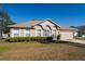Charming single story home with manicured landscaping, a two-car garage and mature trees at 1632 Lansfield Ave, Deltona, FL 32738