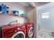 This laundry room features a red washer and dryer set with wire shelving and storage space at 1632 Lansfield Ave, Deltona, FL 32738