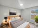Bright bedroom with large window, neutral walls, bedside tables, and artwork above the headboard at 1730 Lochshyre Loop, Ocoee, FL 34761