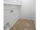 Small laundry room featuring overhead storage shelves and tile floors at 1730 Lochshyre Loop, Ocoee, FL 34761