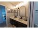 Well-lit bathroom featuring double sinks, dark wood cabinets, and neutral tile flooring at 18907 Rawson St, Orlando, FL 32827