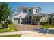 Inviting two-story home with a two-car garage, landscaped lawn, brick driveway, and cozy covered porch at 18907 Rawson St, Orlando, FL 32827