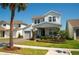 Lovely two-story home with a two-car garage, lush lawn, brick driveway, and charming covered front porch at 18907 Rawson St, Orlando, FL 32827