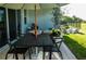 Outdoor dining and lounge area on patio with a black table, chairs, and large umbrella at 18907 Rawson St, Orlando, FL 32827