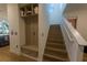Entryway with a coat rack and bench, leading to a staircase with natural wood steps at 18907 Rawson St, Orlando, FL 32827